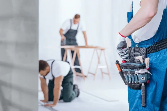 Drei Personen beim Bau eines Gartenhauses